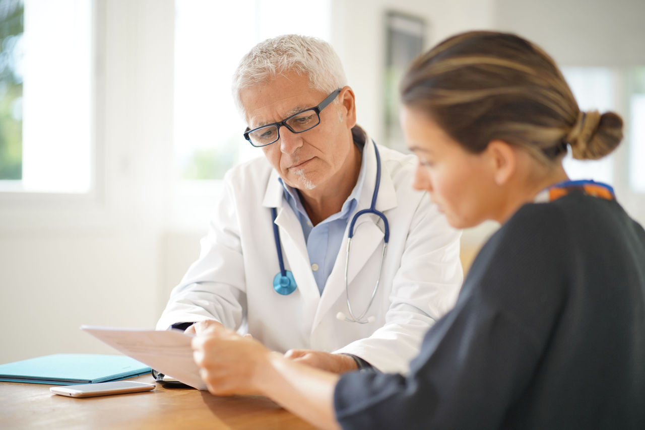 Médecin expliquant des documents médicaux à une patiente.