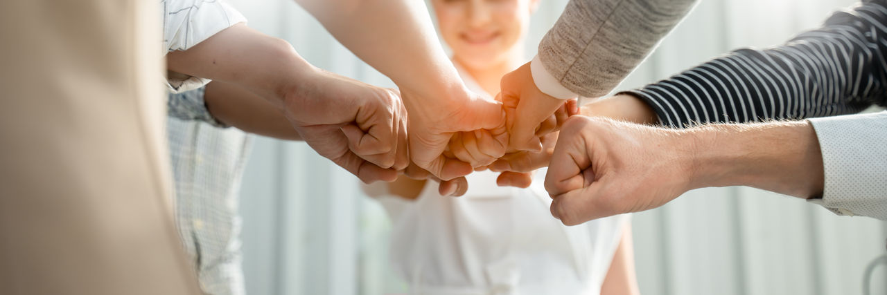 Groupe de mains réunies pour un geste d'équipe.